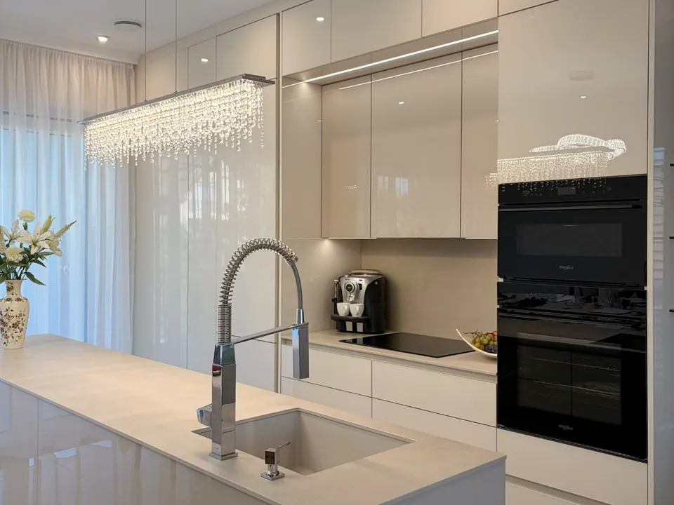 Light, high-gloss, handleless kitchen with an island and a professional tap