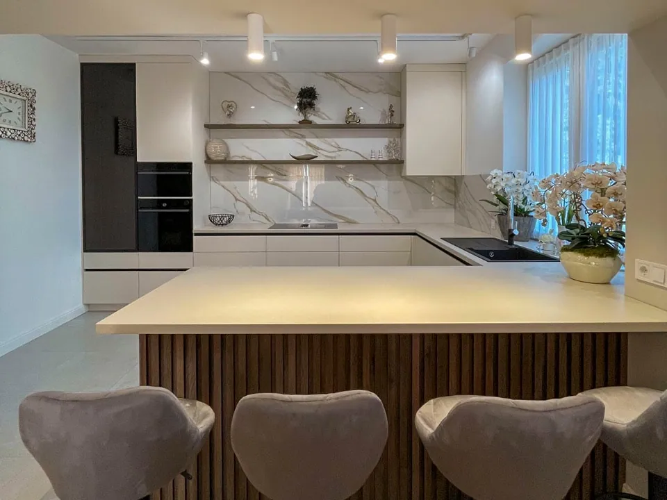Kitchen with a ribbed dark oak island and a gold-veined marble splashback