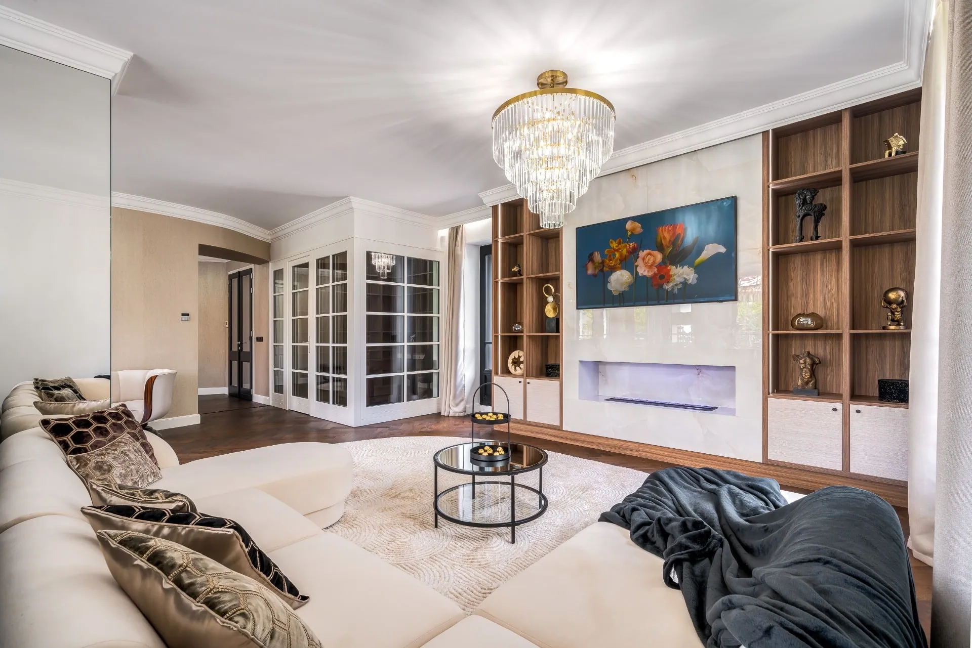 Living room with built-in shelving and a crystal chandelier