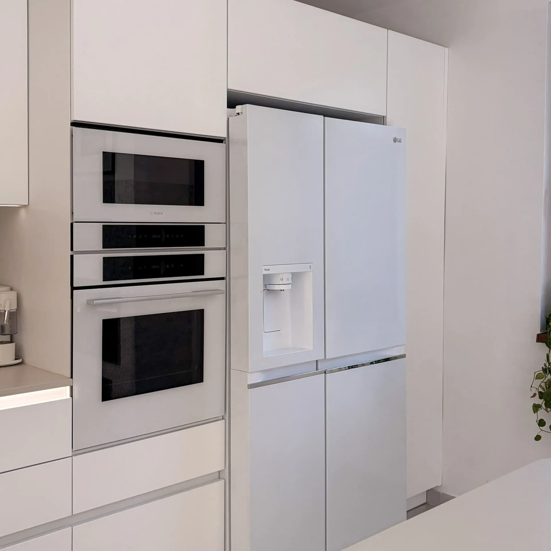 Built-in ovens and fridge in the tall cabinet run