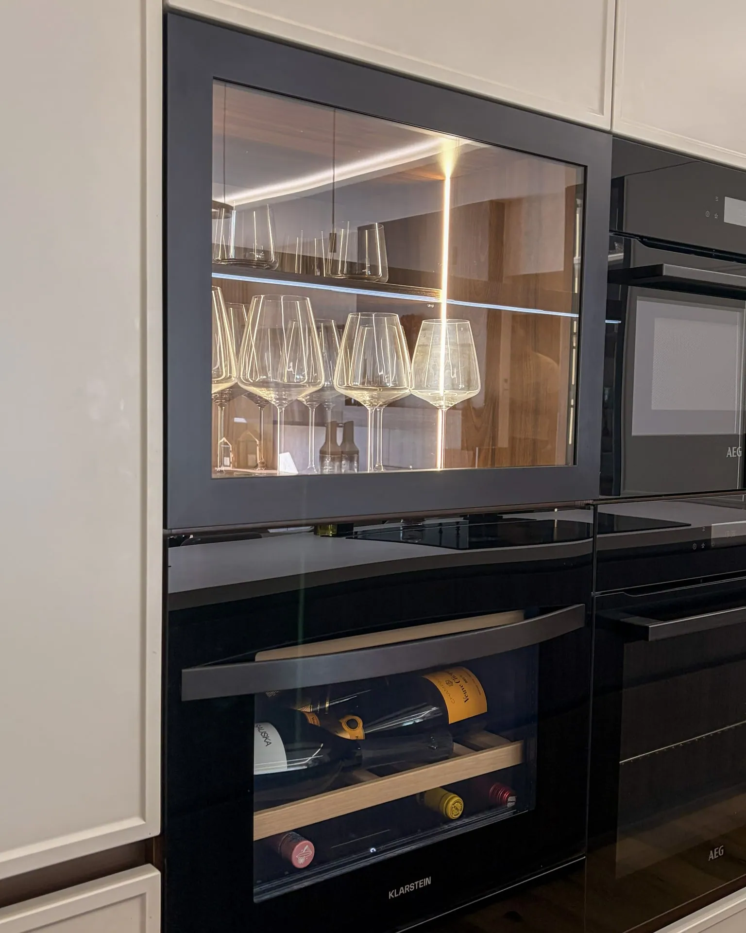 Aluminium-framed wine glass cabinet matched to the microwave, with a wine cooler below