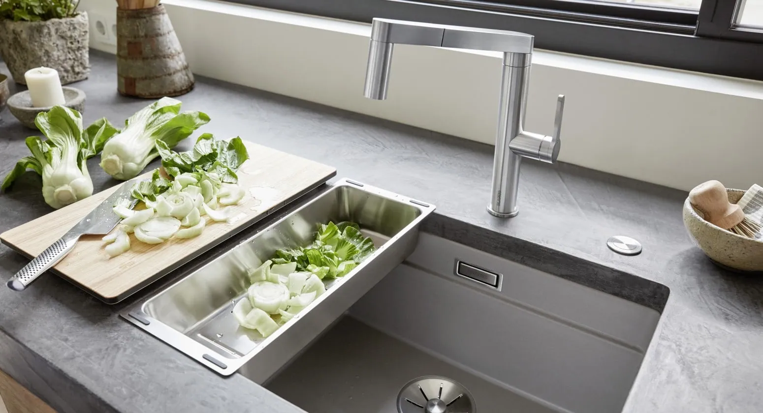 Sink with a sliding chopping board and a colander